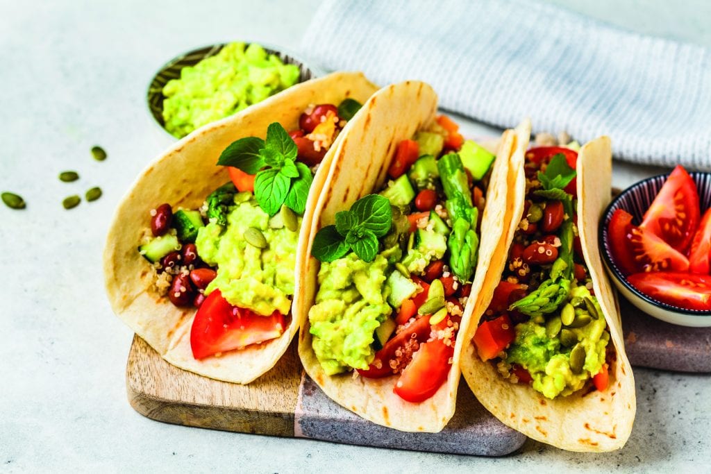 Vegan tortillas with quinoa, asparagus, beans, vegetables and guacamole. Vegan tortilla wraps with quinoa, asparagus, beans, vegetables and guacamole.