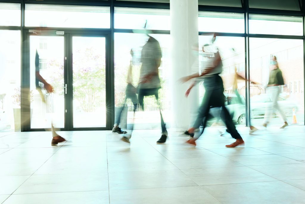 Motion blur, busy office and business people walking, moving or fast speed in workplace, startup company or agency. Group of workers, crowd and employees rush movement in lobby, building and hallway