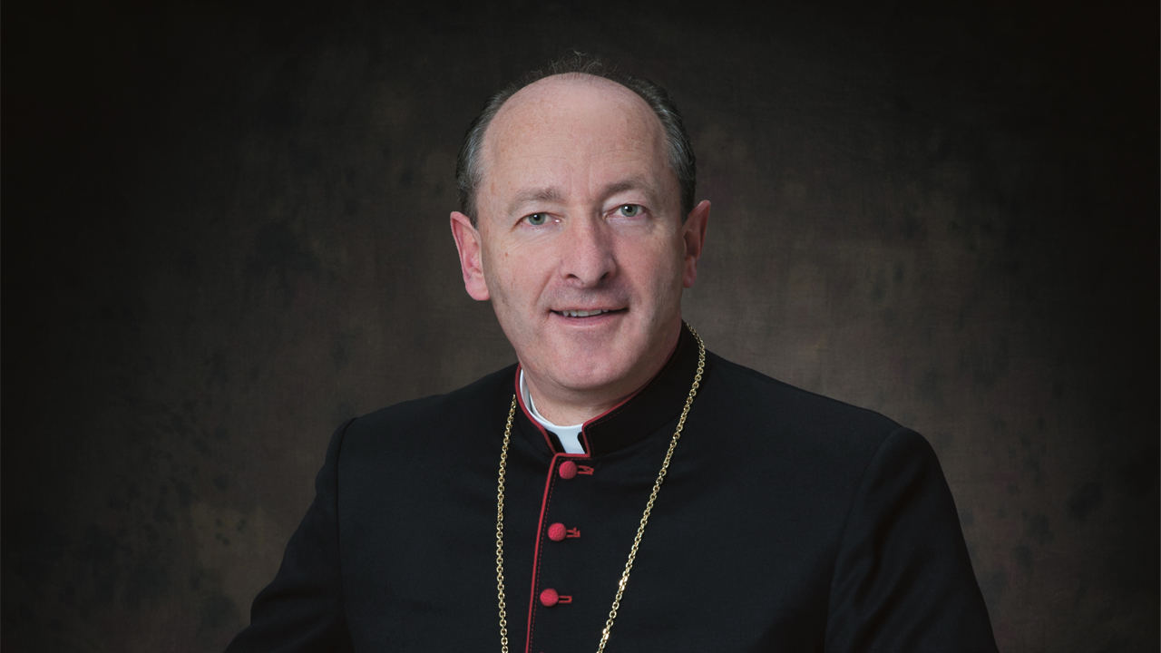 A head-and-shoulders shot of a bishop looking directly at the camera. 