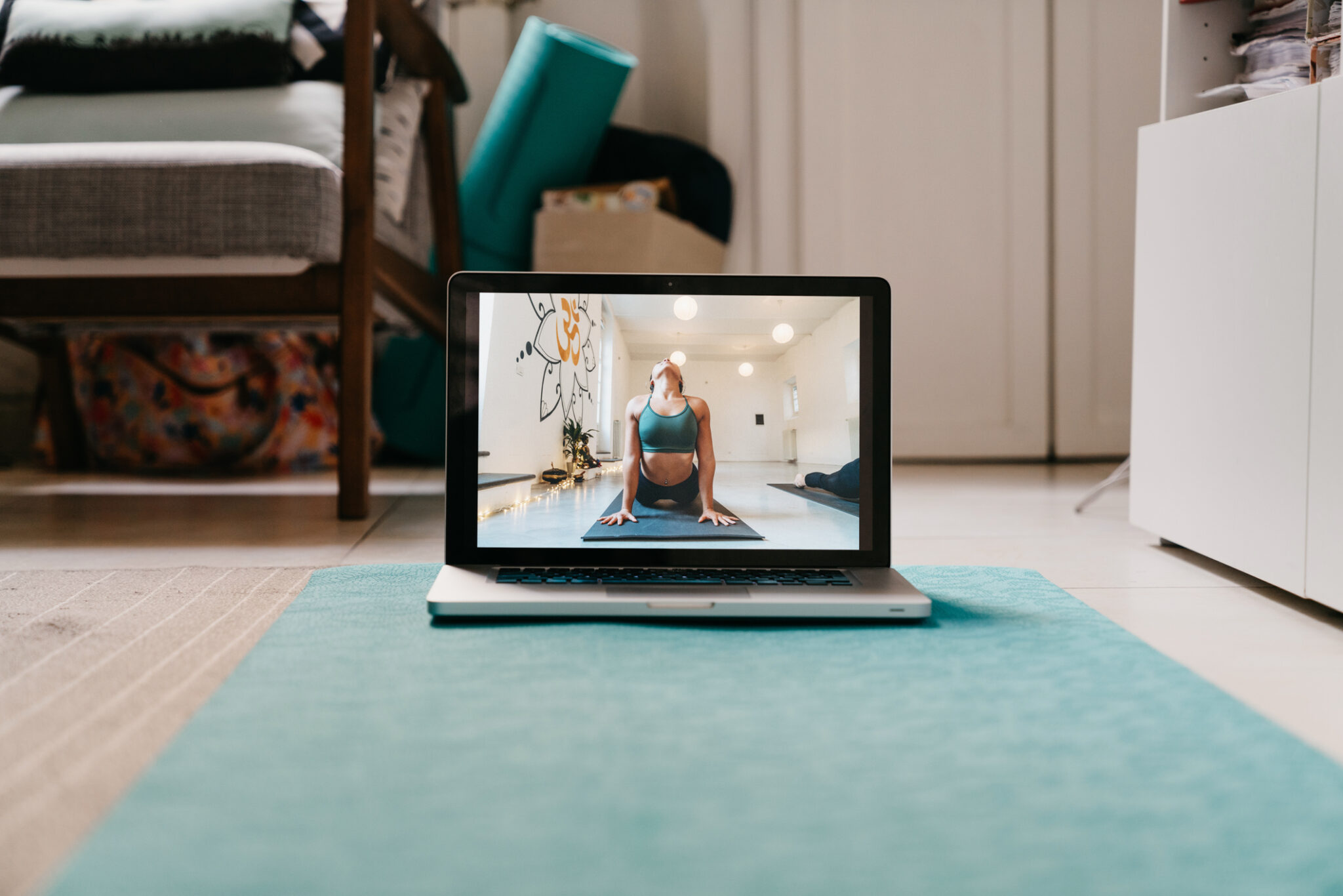 The laptop is ready for an online yoga video lesson. During Coronavirus Covid-19 quarantine, many people is practicing sport at home.