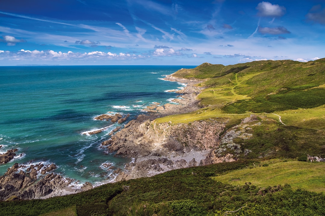 Picturesque view of the North coast of Devon. Grunta beach and Mortehoe point in the distance. Striped sky. England