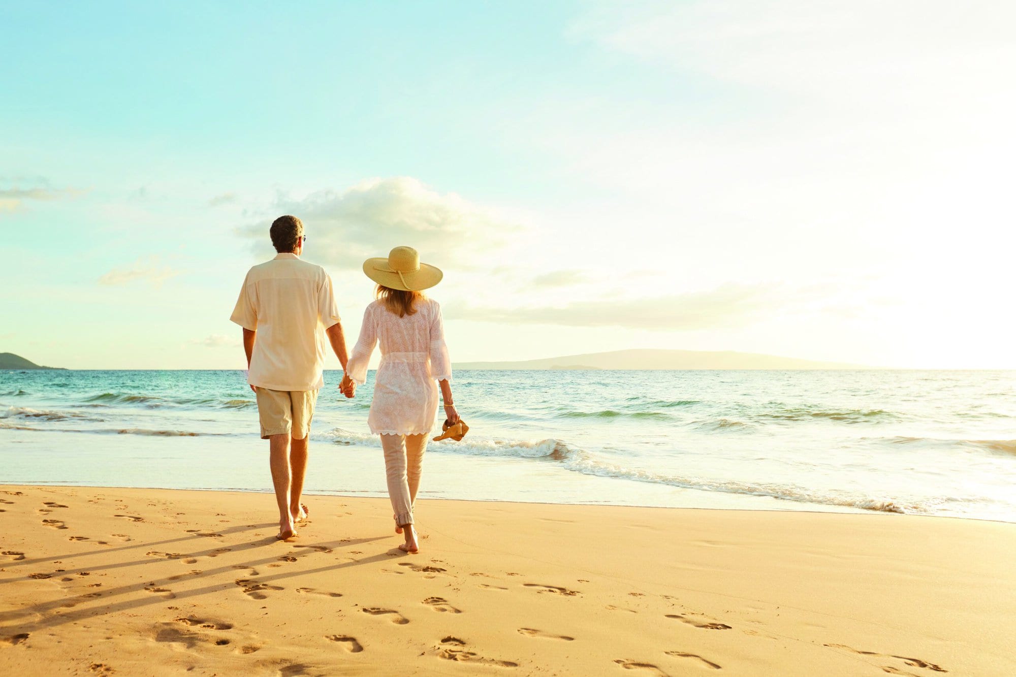 Happy Romantic Middle Aged Couple Enjoying Beautiful Sunset Walk on the Beach. Travel Vacation Retirement Lifestyle Concept