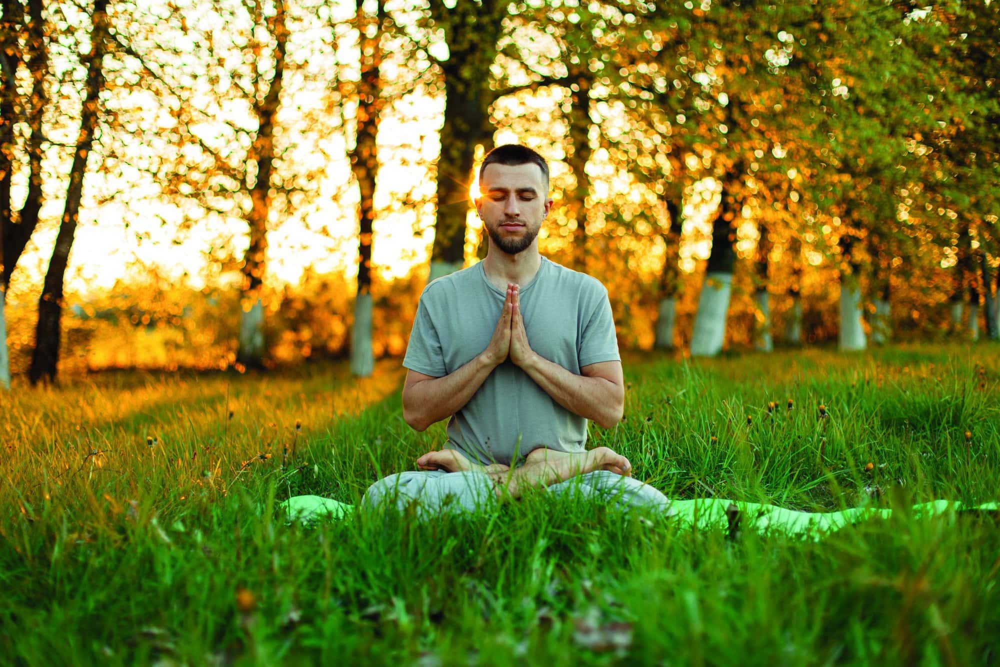 Man meditating in a park at sunset. Healthy lifestyle