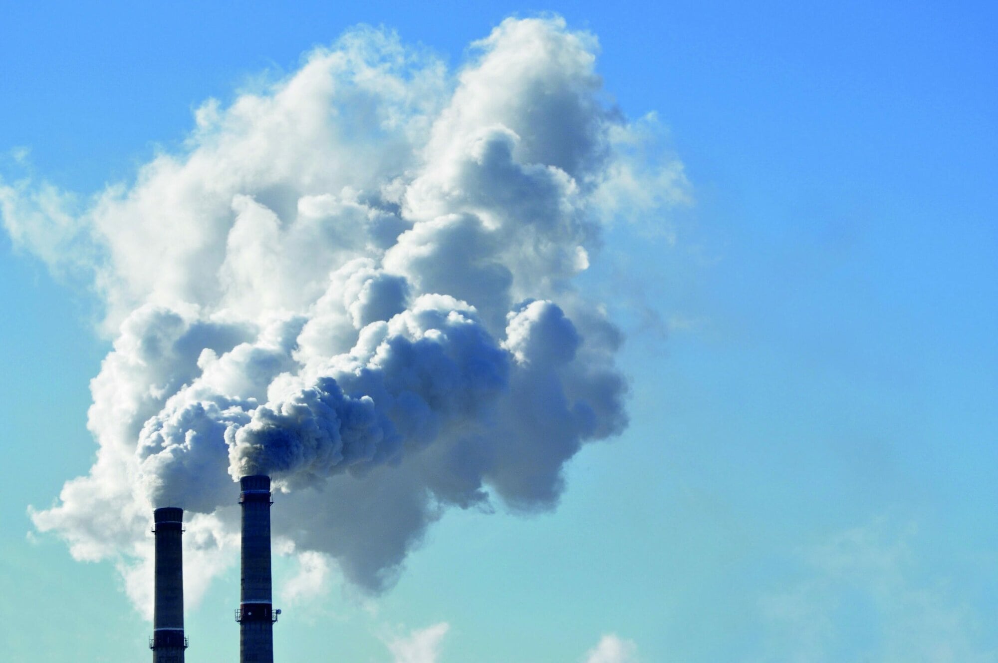 industrial smoke from chimney on blue sky