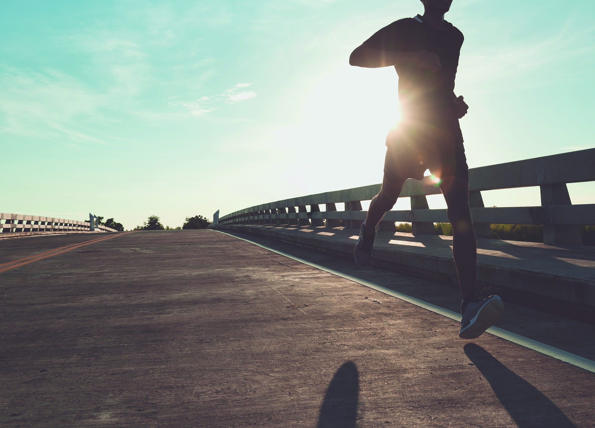 The man with runner on the street be running for exercise.