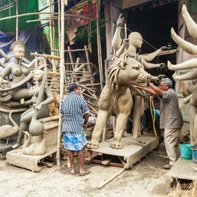 Men pushing in clay sculpture
