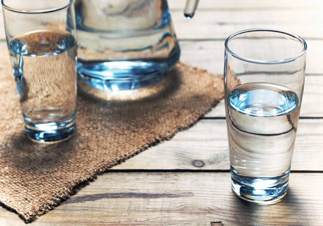 Glasses of water on a wooden table. Selective focus. Shallow DOF