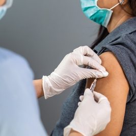 close up doctor holding syringe and using cotton before make injection to patient in medical mask. Covid-19 or coronavirus vaccine